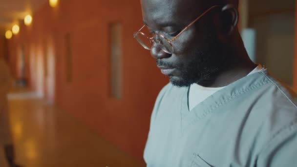 精神病院で働くアフリカ系アメリカ人の医師の閉鎖を傾倒し 医療記録にノートを作る — ストック動画