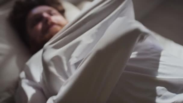 男青年穿着紧身衣躺在病床上试图挣脱双手的选择性聚焦拍摄 — 图库视频影像