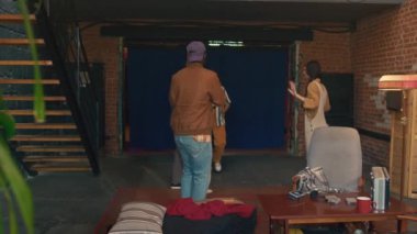 Ağır çekimde, terk edilmiş binada dans eden siyah ve beyaz erkek ve kadınların müzik eşliğinde kamera önünde video çekimleri.