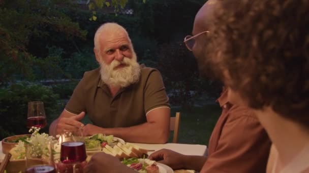有选择性地聚焦于与家人共进晚餐和聊天的大胡子老人的面部照片 — 图库视频影像
