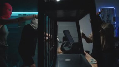 Kar maskeli genç bir çiftin, rehinciyi silahla tehdit edip, para dolu çanta alırkenki el kamerası görüntüsü.