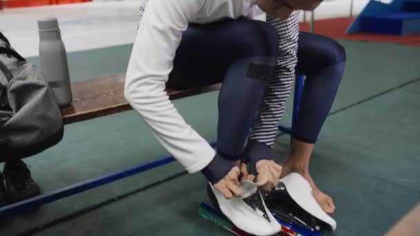 Средний Наклон Ручной Снимок Молодого Человека Сидящего Скамейке Завязывающего Шнурки — стоковое видео