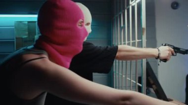 Beyaz ve pembe kar maskeli genç haydutların rehin dükkanlarını soyarken ve tabancalarla tehdit ederken pov çekimi.