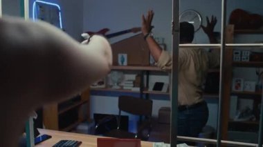 Siyahi erkek tefeciye silah doğrultan iki Kafkasyalı soyguncunun rehin dükkanında istedikleri eşyaları verirken çekilen görüntüler.