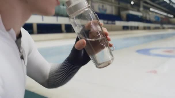 Zijprofiel Handheld Kantelfoto Van Blanke Jonge Atleet Schaatser Schaatspak Drinkwater — Stockvideo