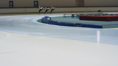 Profesyonel erkek atlet hız patenci grubunun uzun mesafe atışı. Pistte koşuyor ve buz pateni sahasında köşeyi dönüyor.