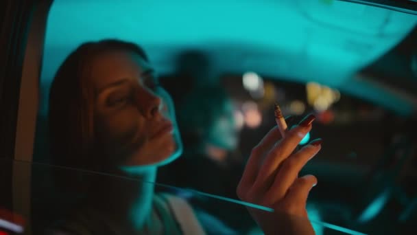 夜に駐車場で車でタバコを吸い アルコールを飲む若い白人カップルのサイドハンドヘルドショットを閉じる — ストック動画