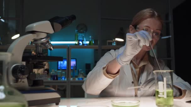 생화학 실험실에서 일하는 화학자의 플라스크에 액체를 피펫으로 조심스럽게 페트리 접시에 — 비디오