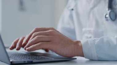 Hastanede dizüstü bilgisayarda yazı yazan tanınmayan bir doktorun ellerine yakından bakın.