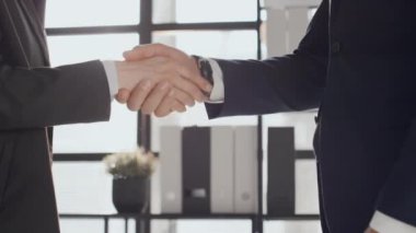 Tanımlanamayan genç iş ortaklarının orta bölüm yavaşlaması ofis toplantısından önce el sıkışmaları ve selamlaşmaları