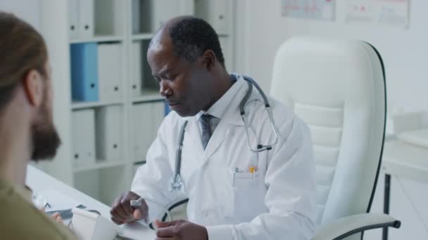 Medelhög Bild Afroamerikansk Terapeut Kardiolog Prata Med Oigenkännlig Patient Och — Stockvideo