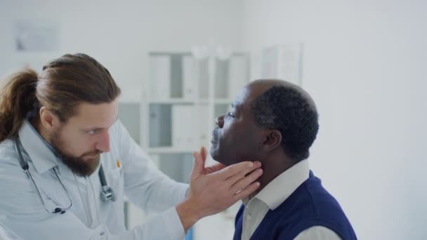 Średnie Ujęcie Boku Kaukaskiego Lekarza Badającego Kark Pacjentów Afroameryki Pod — Wideo stockowe