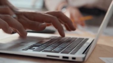 Tanınmayan bir erkeğin laptopa veri girerken ve hafif ofisteki klavye ve touchpad kullanırken çekilmiş yavaş çekimleri kapat.