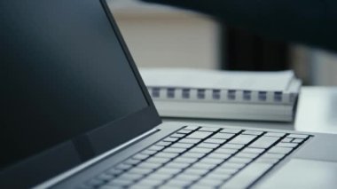 Erkek ellerinin dizüstü bilgisayarı açtığı, uyku modundan uyandırdığı ve ofiste çalışmaya başladığı yakın çekim.