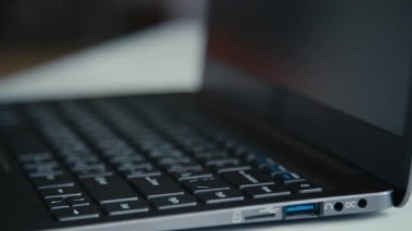 Erkek elinin bilgisayarı açtığı ve ofiste çalışmak için açtığı yakın çekim.