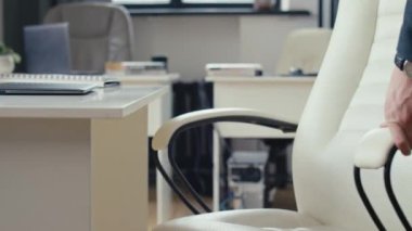 Tanımlanamayan işverenin fildişi deri koltuğa oturup çalışmaya başlaması.