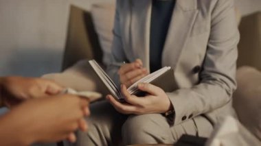 Tanımlanamayan kadın terapistin elleri için seçici odak noktası. Odadaki hastasına sıcak ışıkla tavsiye veriyor.