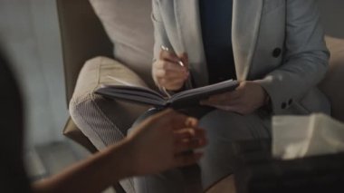 Kadın psikoloğun, odadaki sorununu soğuk yıldırımlarla tarif ettikten sonra not aldığı seçici odak noktası.
