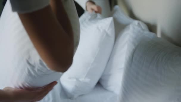 有选择性的聚焦近距离拍摄无法辨认的客房服务员在酒店房间里翻动枕头 准备迎接新客人的镜头 — 图库视频影像