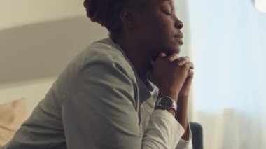 Hastane üniformalı, yorgun, uykucu, Afro-Amerikan bir kadının evde ya da iş yerinde kanepede oturup, boyun kaslarına masaj yaparken ve...