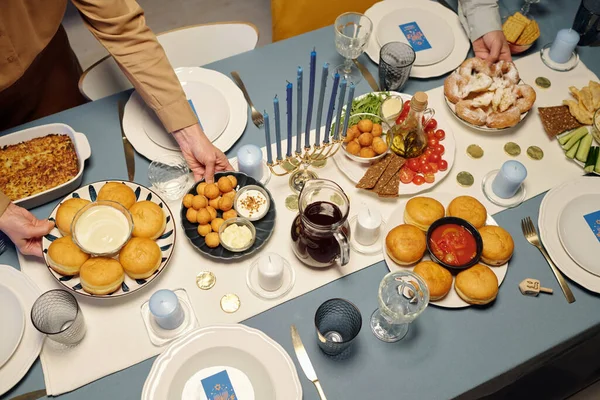 上图是一个不知名的男人和女人把自制的小吃放在桌上 并配上为光明节晚餐准备的美味食物 — 图库照片