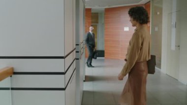 Kafkasyalı kadın ofis çalışanının modern ofiste iş günü asansöre binerken yavaş çekimleri.