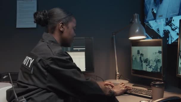 若いアフリカ系アメリカ人女性警備員の肖像画とコンピュータで作業する勇敢さ そして監視室でカメラと微笑みに変える — ストック動画