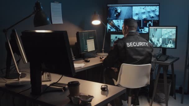 Zadní Pohled Mužského Bezpečnostního Důstojníka Používajícího Ruční Vysílač Ukazující Podezřelé — Stock video