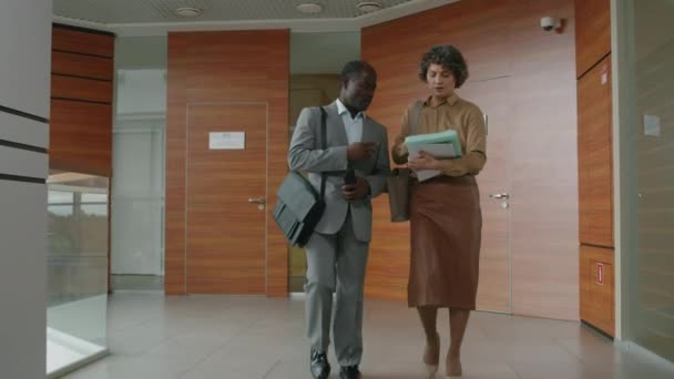 사무실 복도를 파일에 아프리카계 미국인 관리자를 컨설팅하는 코카서스 직원의 슬로우 — 비디오