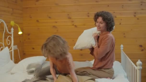 Średnie Ujęcie Matki Jej Syna Zabawnie Walczących Poduszkami Łóżku Dobrze — Wideo stockowe