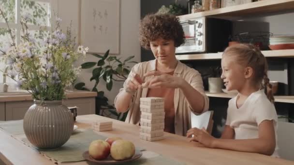 快乐的白人母亲和女儿坐在舒适的厨房建筑木制砖塔中餐桌旁的画像 — 图库视频影像