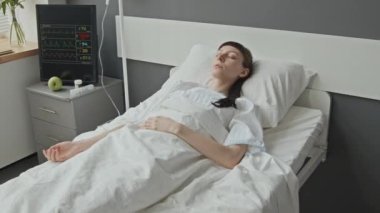 Hastanın yanında yatan beyaz kadının orta boy görüntüsü, monitör.