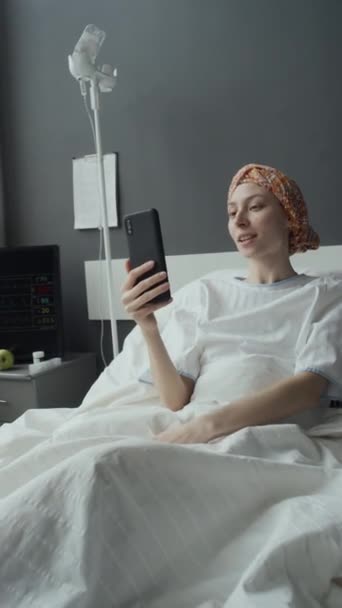 病院区の化学療法を通過しながら コカシアの若い女性が電話で話している垂直中型ショット — ストック動画