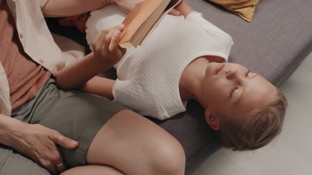 母親と一緒に自宅でリラックスしながら読書するコーカサス女の子の高角度ビューショット — ストック動画