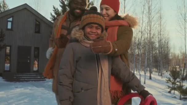 田舎で冬休みを過ごす陽気な民族的に多様な親と子供のミディアムロー角度の肖像画 — ストック動画