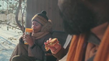 Etnik çeşitlilikte baba, anne ve oğullarının kış günü dışarıda oturup yemek yedikleri seçmeli bir odak noktası.