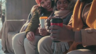 Siyah adamın elinde termal bardakla çay ya da kahveyle kış günü karısı ve oğluyla dışarıda vakit geçirdiği seçmeli bir fotoğraf.