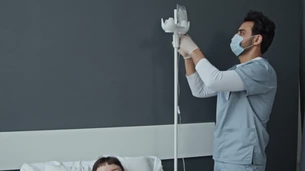 ウイルスの発生時に女性患者を世話するマスクの医師と看護師のパンニングショット — ストック動画