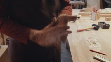 Üst düzey oduncunun talaş sallarken eliyle yapılan seçici odaklanma görüntüsü.