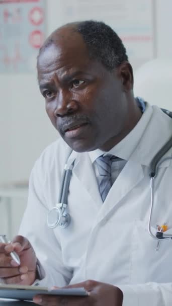 Κάθετη Λήψη Του Αφροαμερικανού Γιατρού Μιλώντας Τον Ασθενή Για Θέματα — Αρχείο Βίντεο