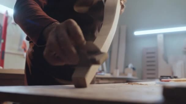 サンドペーパーで滑らかにしながら木の部分に特別な技術を使用して認識できない男性の木工の選択的なフォーカスクローズアップショット — ストック動画