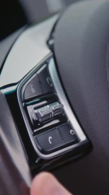 Sürücülerin dikey çekimini yakından çek. Elle cevap ver. Konuşma düğmesi kullan ve direksiyonda asılı bırak düğmesine bas.