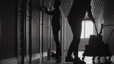 Karanlık uzun koridoru temizleyen birkaç hademenin monokromatik çekimini kaldırıyorum.