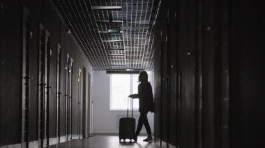 Otel odasına bavullu, tanınmayan bir iş kadınının uzun siyah beyaz bir fotoğrafı geliyor.