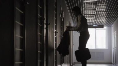 Ofisin önünde duran tanınmayan bir adamın ceketini giydiği bir fotoğraf. Acele et.