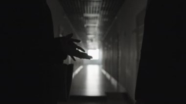 Karanlık koridorda el sıkışan iki ofis çalışanının orta boy yakın çekimi.