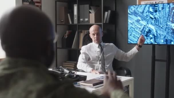身着正装的军事教授肩并肩地指着屏幕上的卫星地图 在军事学院的研讨会上要求不知名的学员回答 — 图库视频影像
