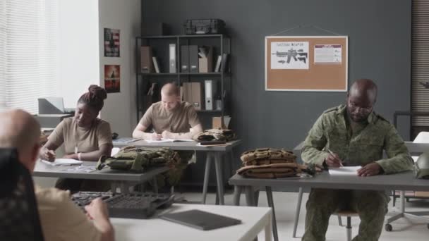 軍事アカデミーの講義クラスで書くカモフラージュの制服の多様な女性と男性のキャデットのフルショット — ストック動画