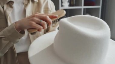 Beyaz şapkayı fırça kullanarak düzelten kadının seçici odaklanma görüntüsü