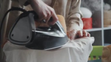 Kafkas kadın zanaatkarının yeni keçeli şapkasını peynir beziyle ütülediği yakın çekim.